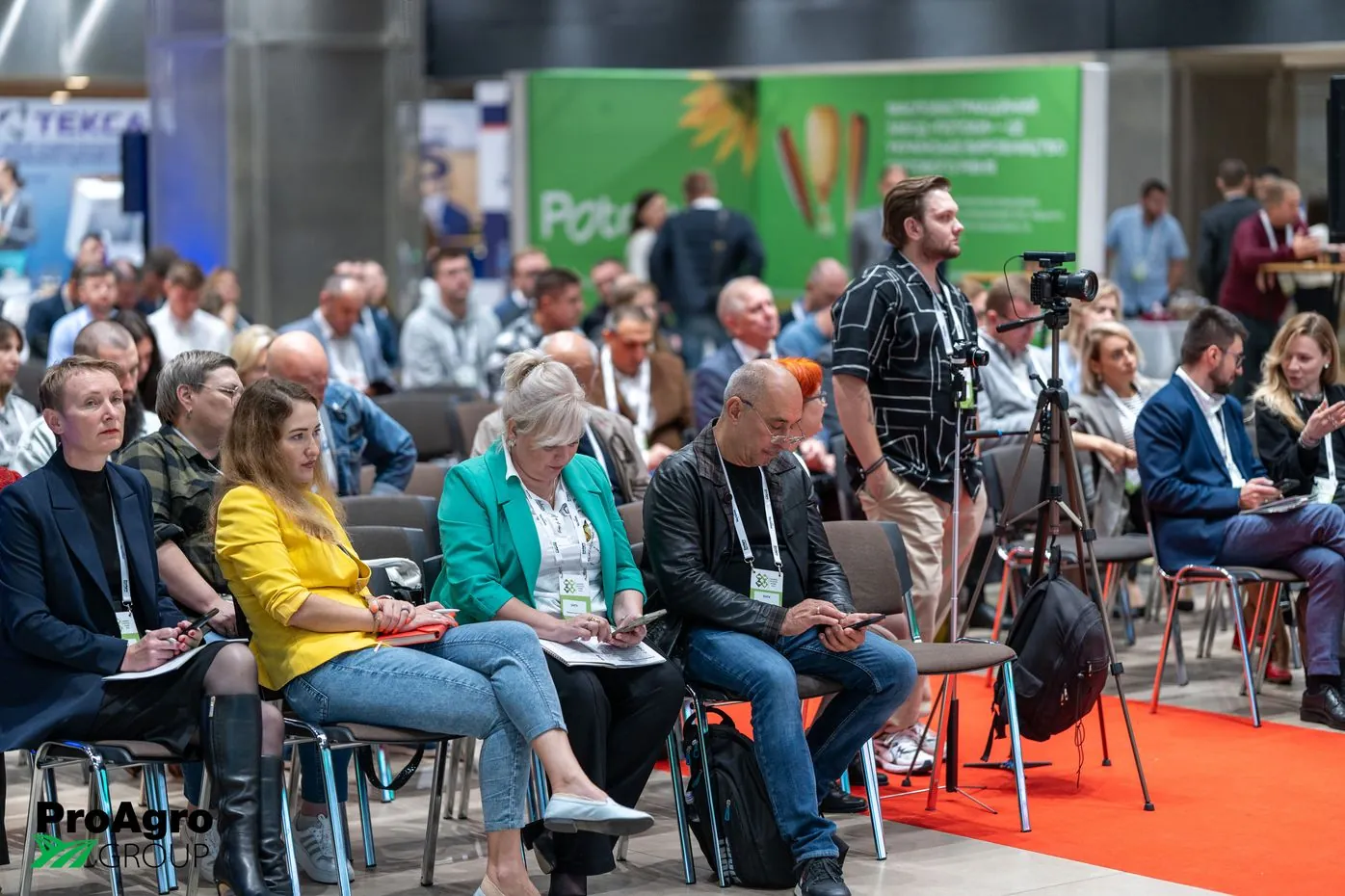 Глядачі слухають доповідь під час Ukrainian Livestock Summit 2024, великий екран зі спікером