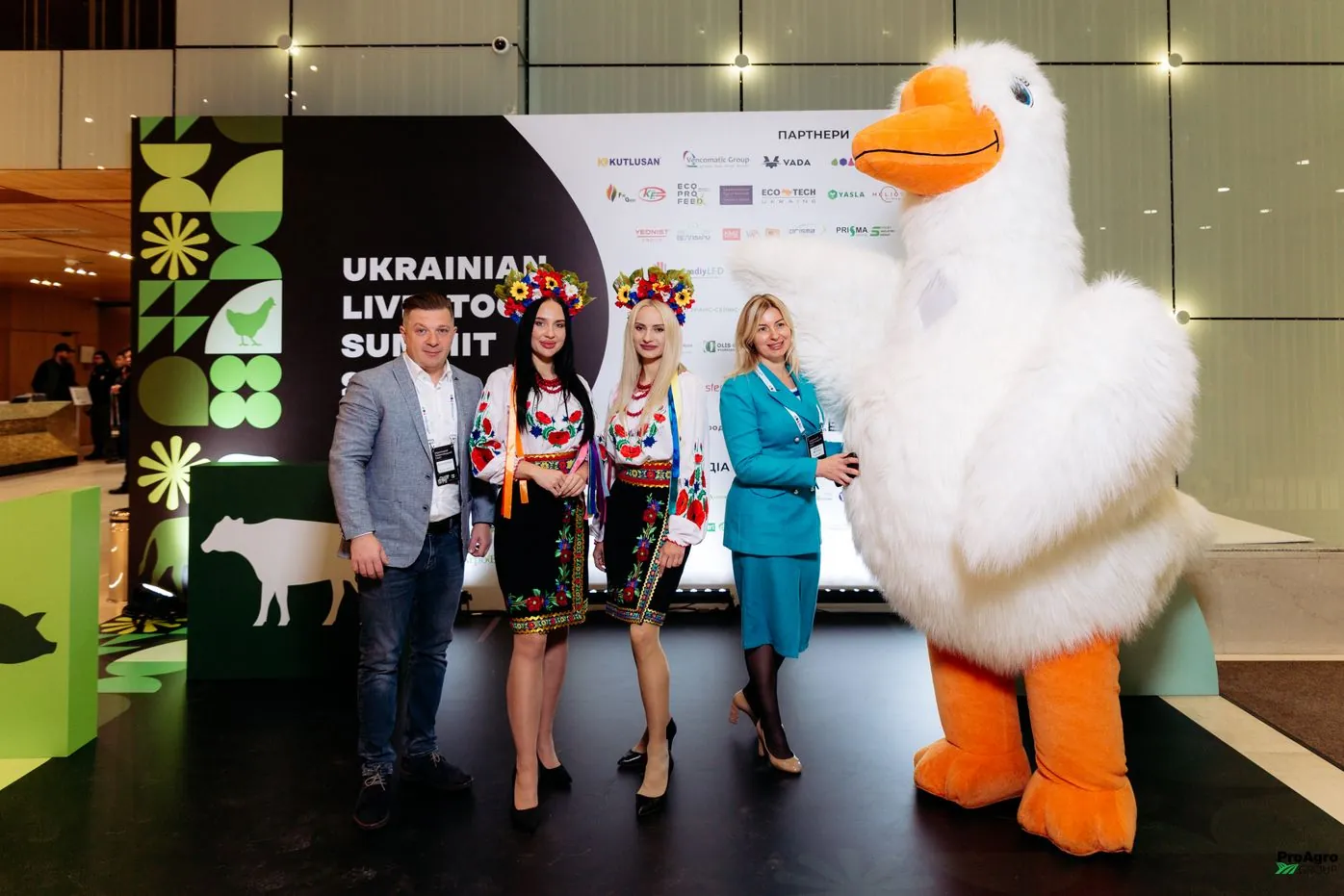 Маскот у вигляді корови на Ukrainian Livestock Summit 2024 поруч з учасниками